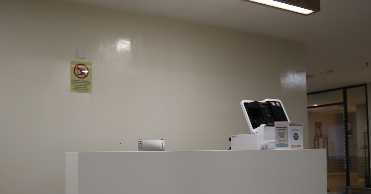 Balcão de recepção de clínica com tablet de atendimento
