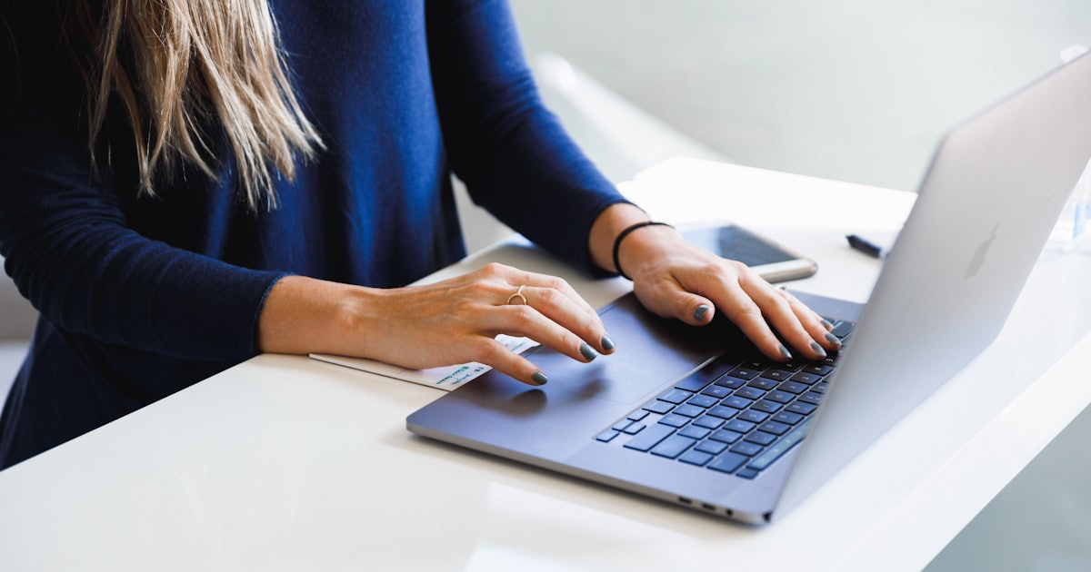Mulher digitando em um notebook — a escrita dos textos do site da clínica
